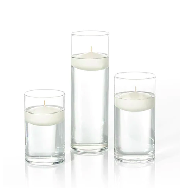 three glass hurricanes with white floating candles