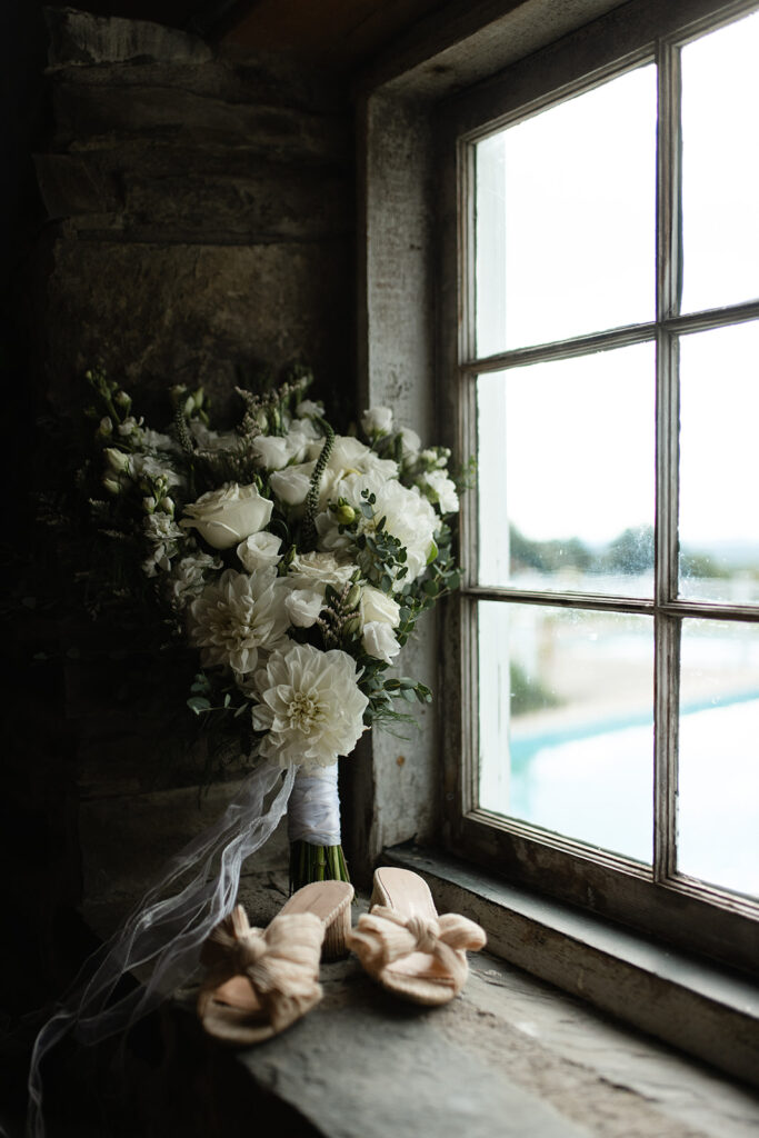 white and green bridal bouquet and heels on a stone window in Upstate New York 