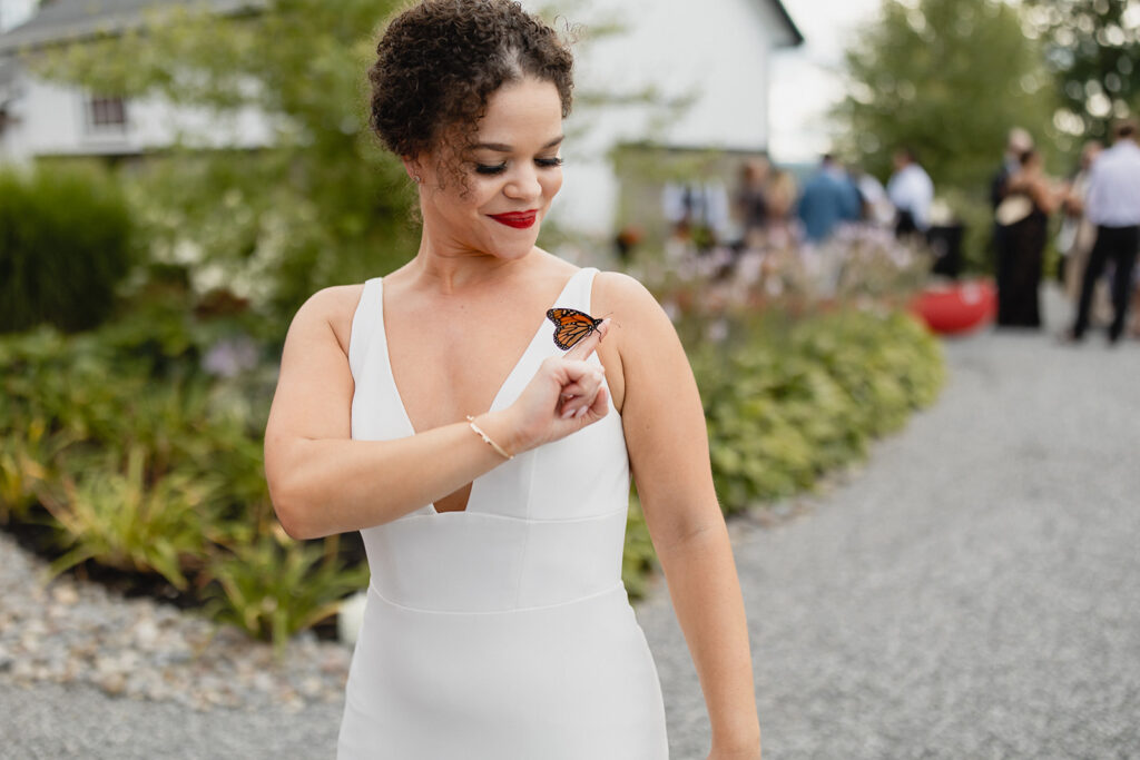 bride holds monarch butterfly on finger