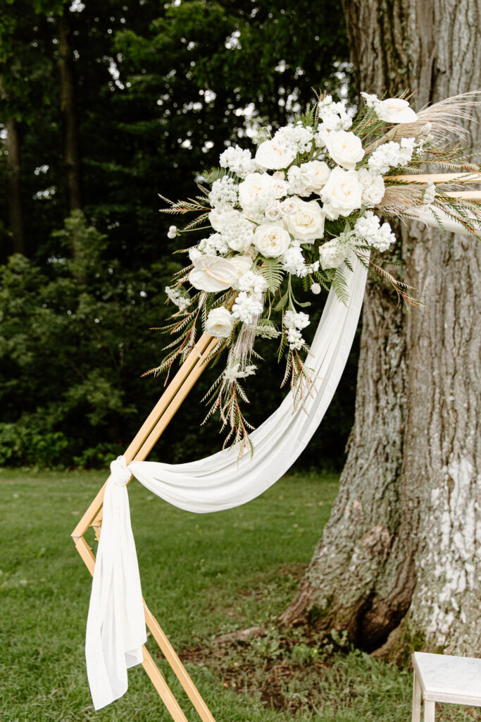 detail shot of white floral pop on gold hexagon wedding arbor for outside ceremony