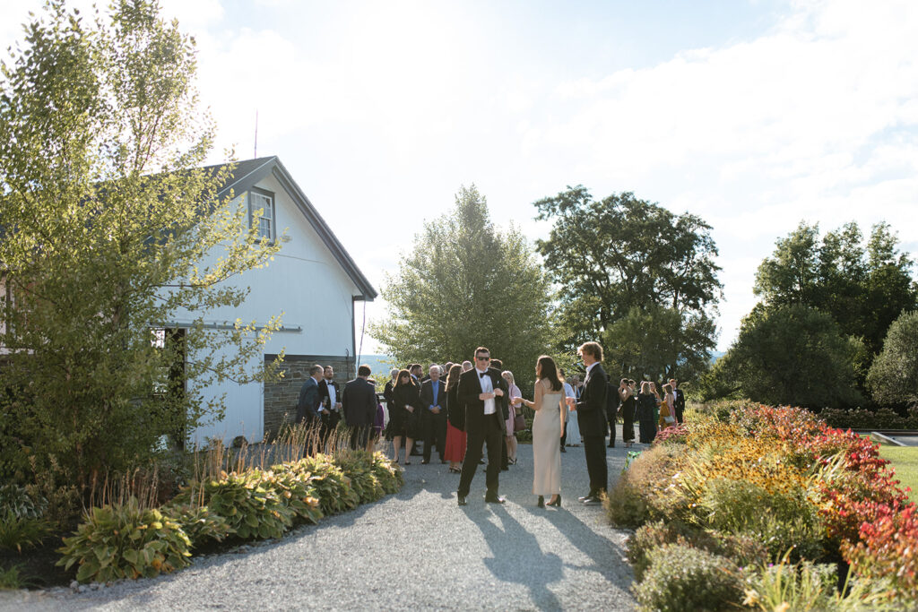 guests mingling outside of white barn at Windridge Estate in Upstate New York