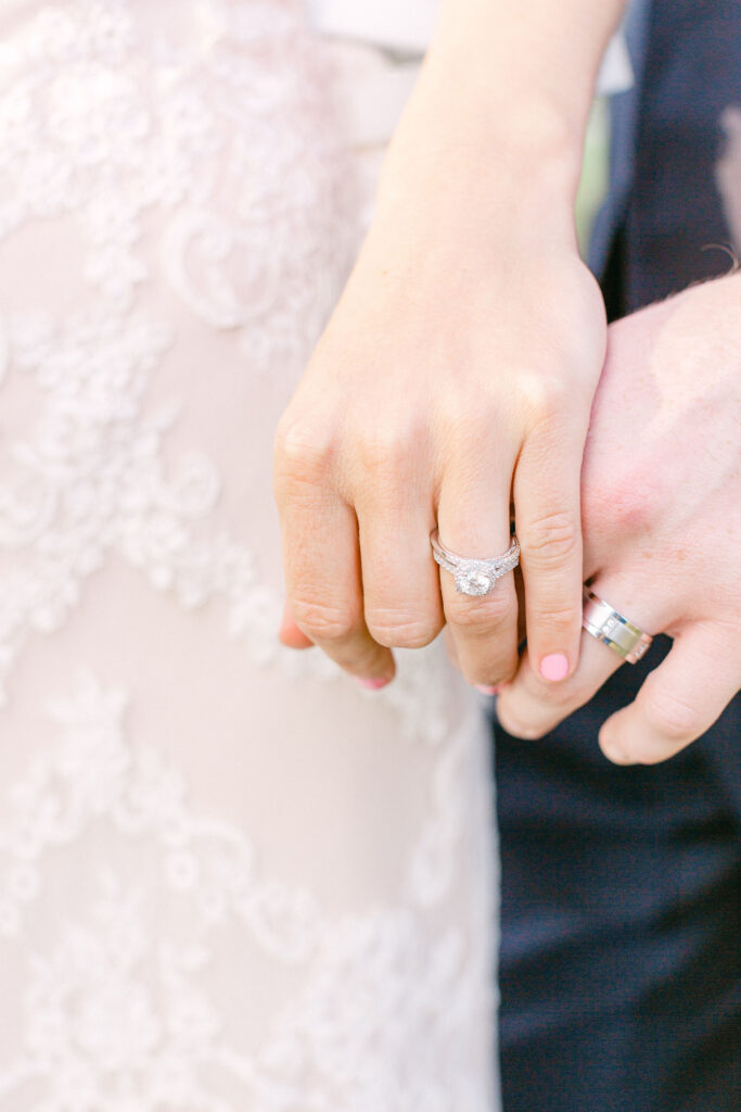 couple holds hands showing off their wedding bands