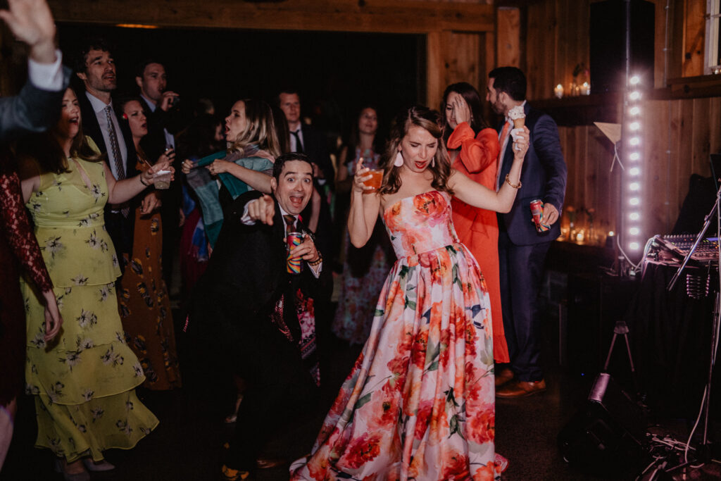bride in colorful wedding dress on the dance floor with guests at weekend wedding venue in upstate new york