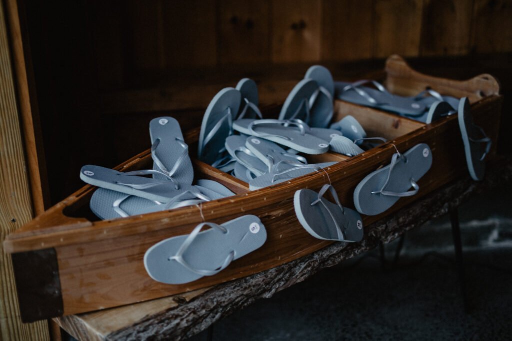 small wood boat shelf filled with blue flip flops for a wedding reception