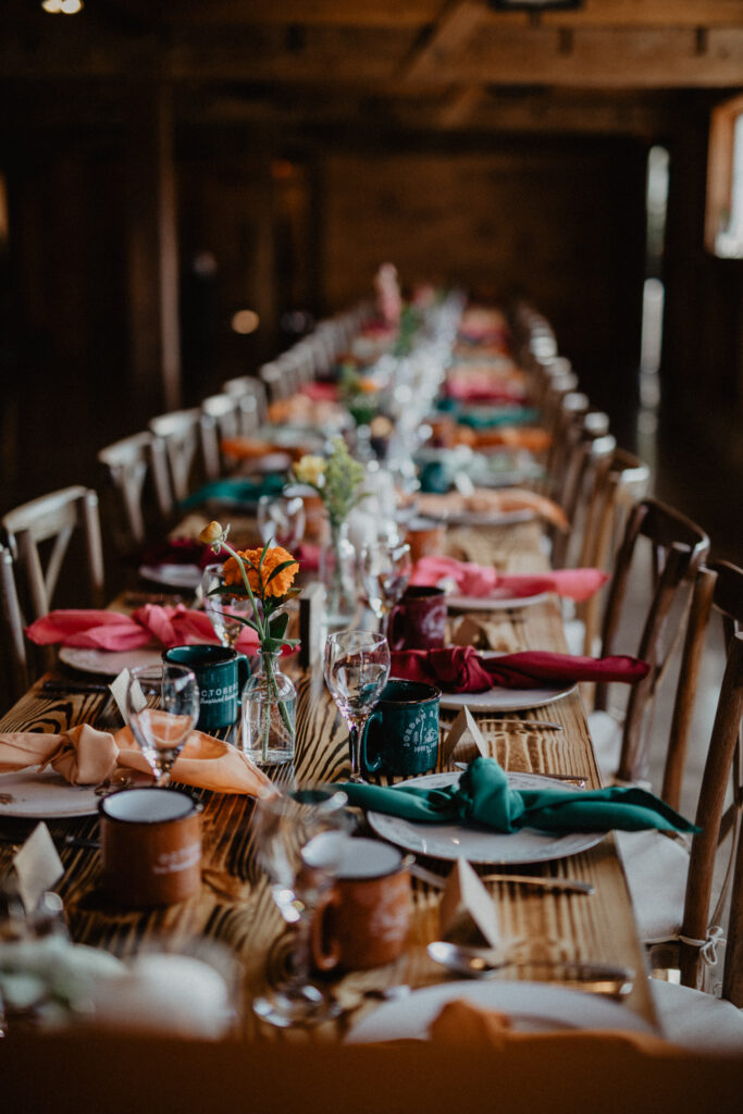 long wood farm tables decorated for a summer camp wedding in upstate new york