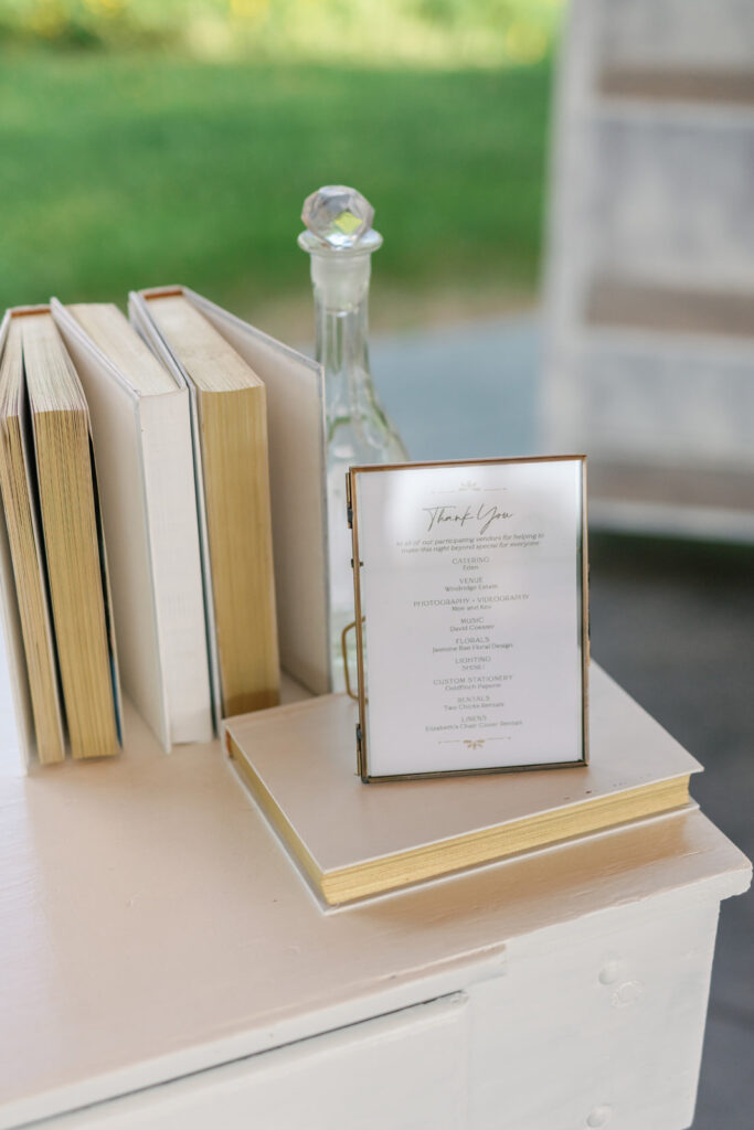 white books and vintage decanter styling on a white bar outside
